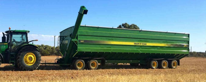 Field Bin in field of crops ready for harvesting green field bin green tractor