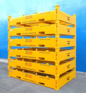 Yellow metal pallets stacked against a blue wall.